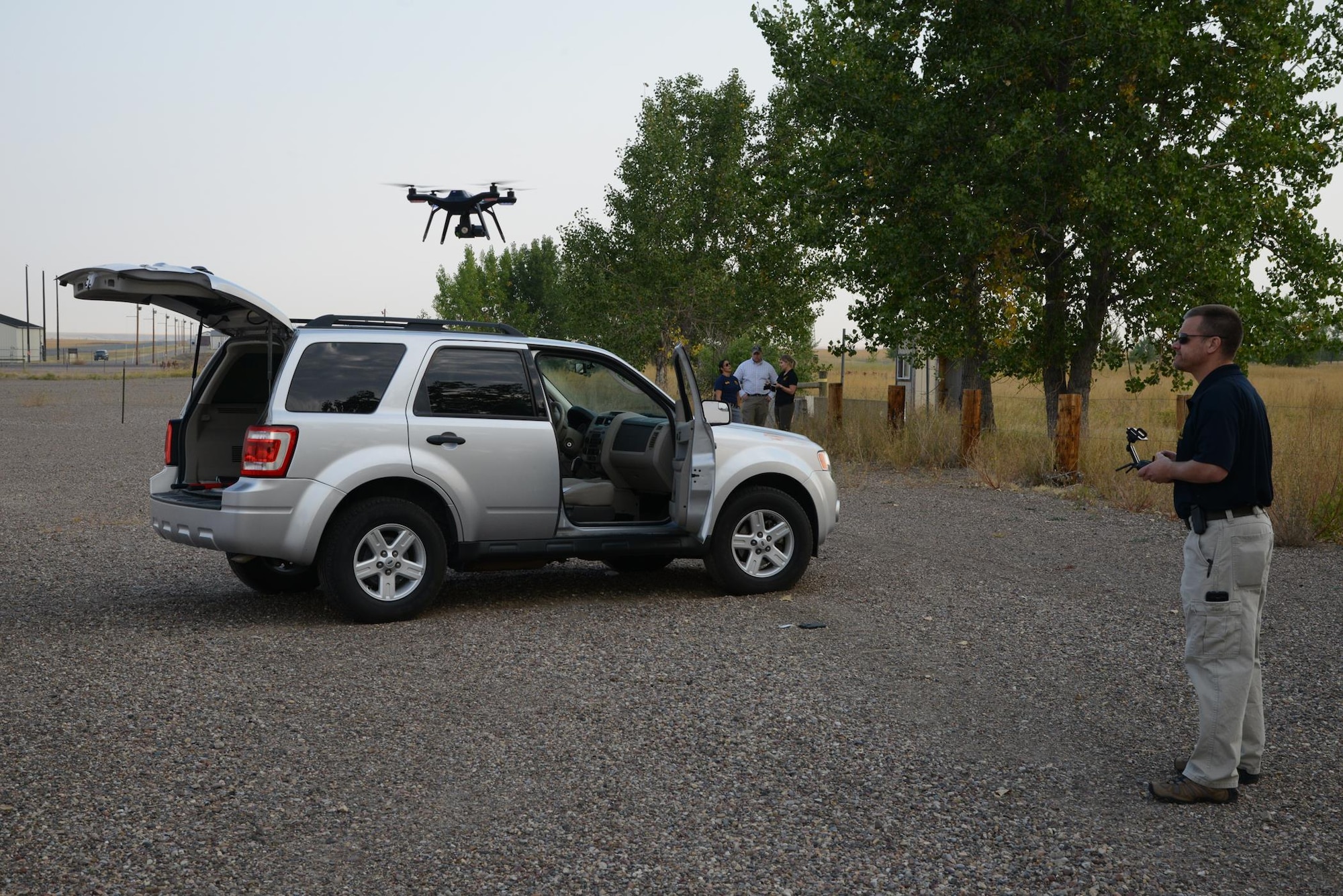 A special agent from the Office of Special Investigations headquarters controls a drone above a simulated crime scene during a training exercise Aug. 29, 2017, at Malmstrom Air Force Base, Mont. The drone was used to collect photographic evidence and test capabilities in a complex crime scene. (U.S. Air Force photo/Staff Sgt. Delia Martinez)