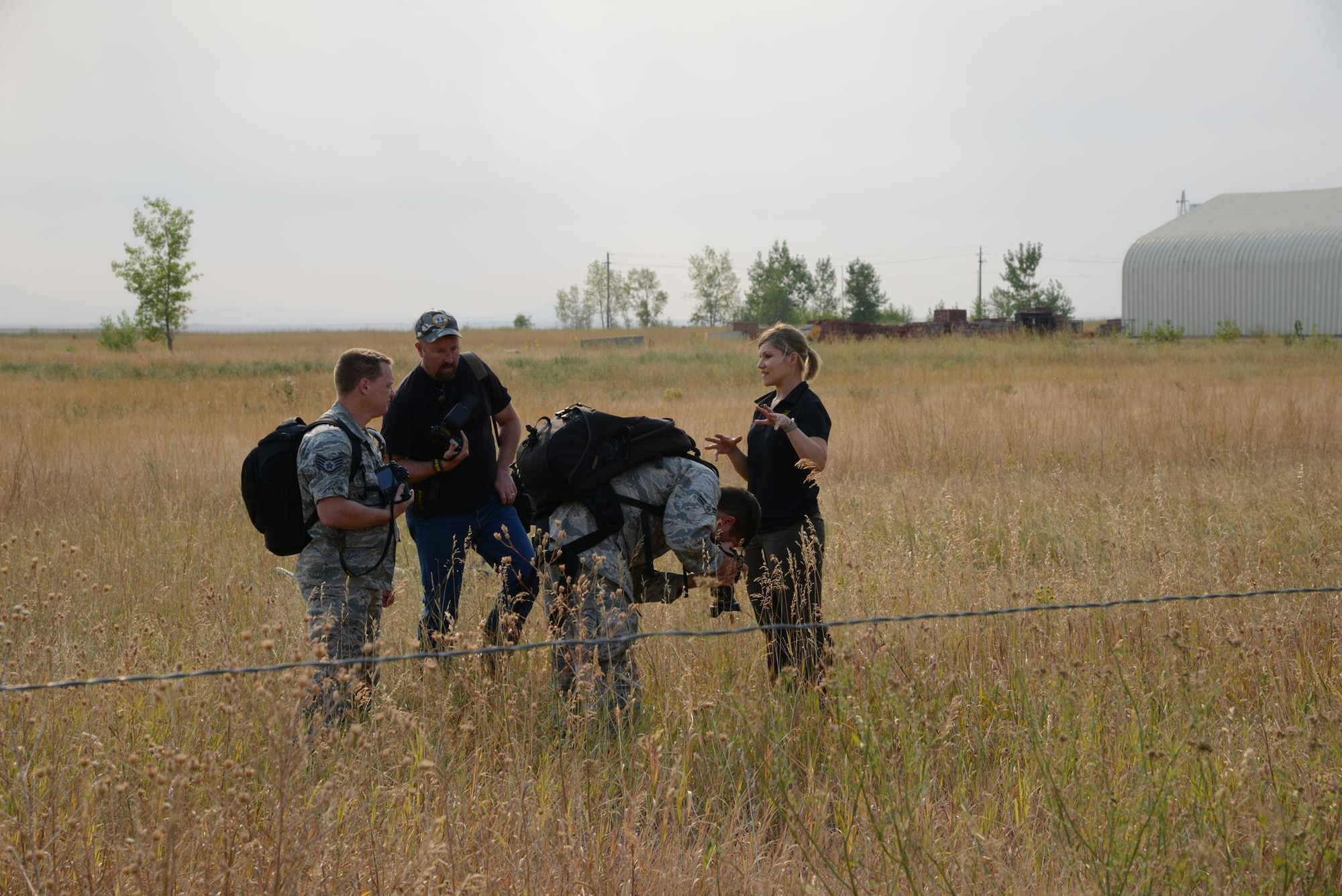 An Office of Special Investigations forensic science agent from Buckley Air Force Base, Colo., guides photojournalists from the Malmstrom public affairs office through crime scene photography during a training exercise Aug. 29, 2017, at Malmstrom Air Force Base, Mont. The forensic science agent trained the photojournalists on the best positions and angles for crime scene documentation. (U.S. Air Force photo/Staff Sgt. Delia Martinez)