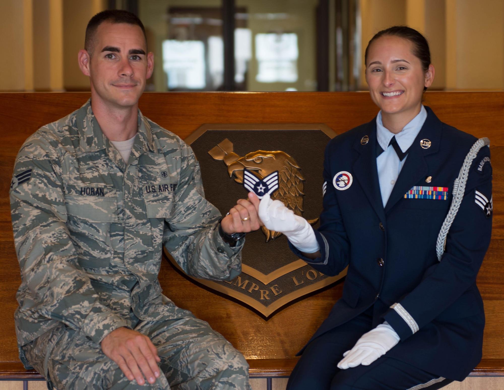 Senior Airmen Joshua and Kelsey Horan, a married couple in the 96th Medical Group, hold up their promotion stripes.