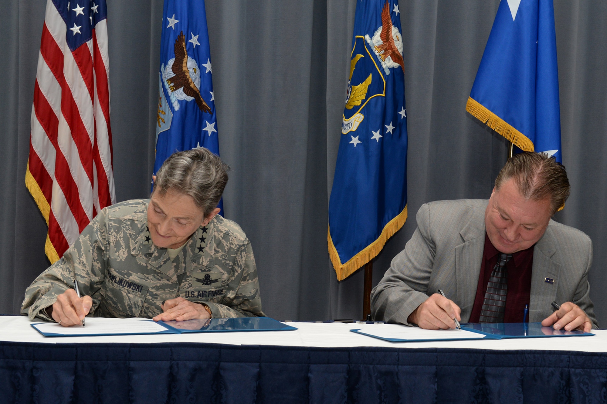 Gen. Ellen M. Pawlikowski, Air Force Materiel Command commander, and Troy Tingey, American Federation of Government Employees Council 214 president, add their signatures to the Master Labor Agreement during a signing ceremony at Headquarters Air Force Materiel Command Aug. 23, 2017. (U.S. Air Force photo/Michelle Gigante)
