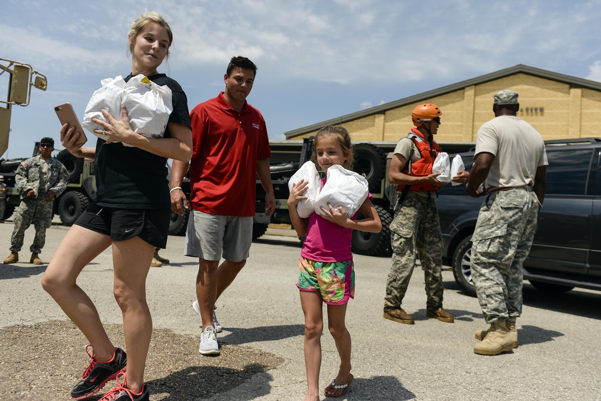 A child and a group of adults carry plastic bags.