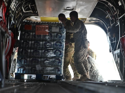 Sgt. 1st Class Aaron Potter, a CH-47 helicopter repairer with 2nd Battalion, 501st Aviation Regiment from Fort Bliss, Texas, pushes a pallet of water on a CH-47 Chinook Sept. 3 at Joint Base San Antonio-Auxiliary Airfield in Seguin, Texas, for a supply deliver to citizens affected by Hurricane Harvey.