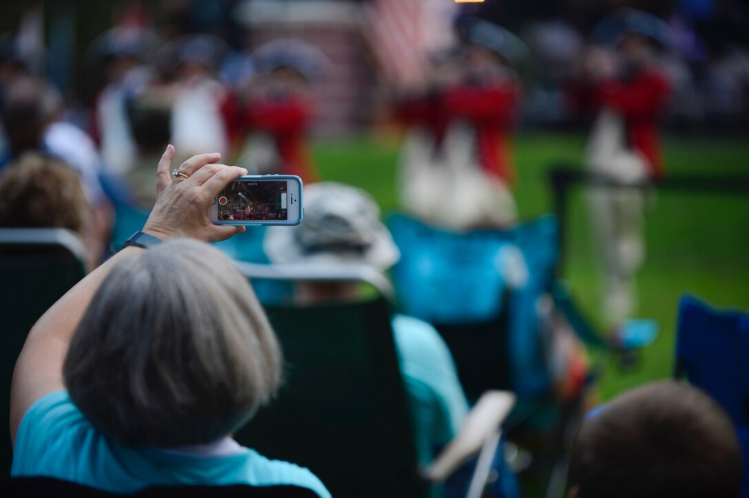 An attendee records the U.S. Army Old Guard Fife and Drum Corps performance at the season finale of the “Music Under the Stars” concert series at Joint Base Langley-Eustis, Va., Aug. 31, 2017.