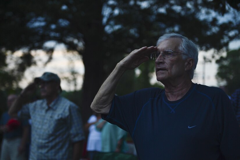 Attendees salute during the national anthem at the “Music Under the Stars” season finale concert at Joint Base Langley-Eustis, Va., Aug. 31, 2017.