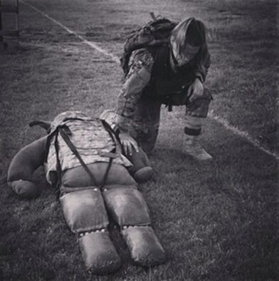 Capt. Kaci Dixon takes a knee to rest after dragging a 200-pound dummy with 30 pounds of gear through an obstacle course in June 2015 at Lackland Air Force Base, Texas. She was participating in the Women in Service Review. (Courtesy photo)