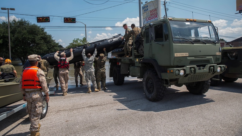 Marines with Charlie Company, 4th Reconnaissance Battalion, 4th Marine Division, Marine Forces Reserve, Texas State Guardsmen and members of the Texas National Guard, unload a Marine Corps F470 Zodiac Combat Rubber Raiding crafts on to a flooded street in Houston, Texas, Aug. 31, 2017. Marines from Charlie Company assisted rescue effort in wake of Hurricane Harvey by providing Zodiacs and personal to local law enforcement.
