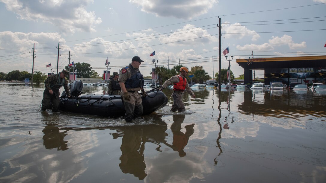 Marines with Charlie Company, 4th Reconnaissance Battalion, 4th Marine Division, Marine Forces Reserve, along with a member of the Texas Highway Patrol and Texas State Guard, pull a Marine Corps F470 Zodiacs Combat Rubber Raiding craft past a flooded car dealership in Houston, Texas, Aug. 31, 2017. Marines from Charlie Company assisted Texas Highway Patrolmen during rescue effort in wake of Hurricane Harvey which landed Aug. 25, 2017, and displaced over 30,000 people.