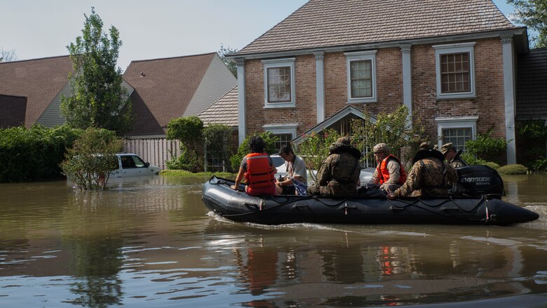 A Marine with Charlie Company, 4th Reconnaissance Battalion, 4th Marine Division, Marine Forces Reserve, along with a member of the Texas Highway Patrol and Texas State Guard, escort a couple to higher ground, Houston, Texas, Aug. 31, 2017. Hurricane Harvey landed Aug. 25, 2017, flooding thousands of homes and displaced over 30,000 people.