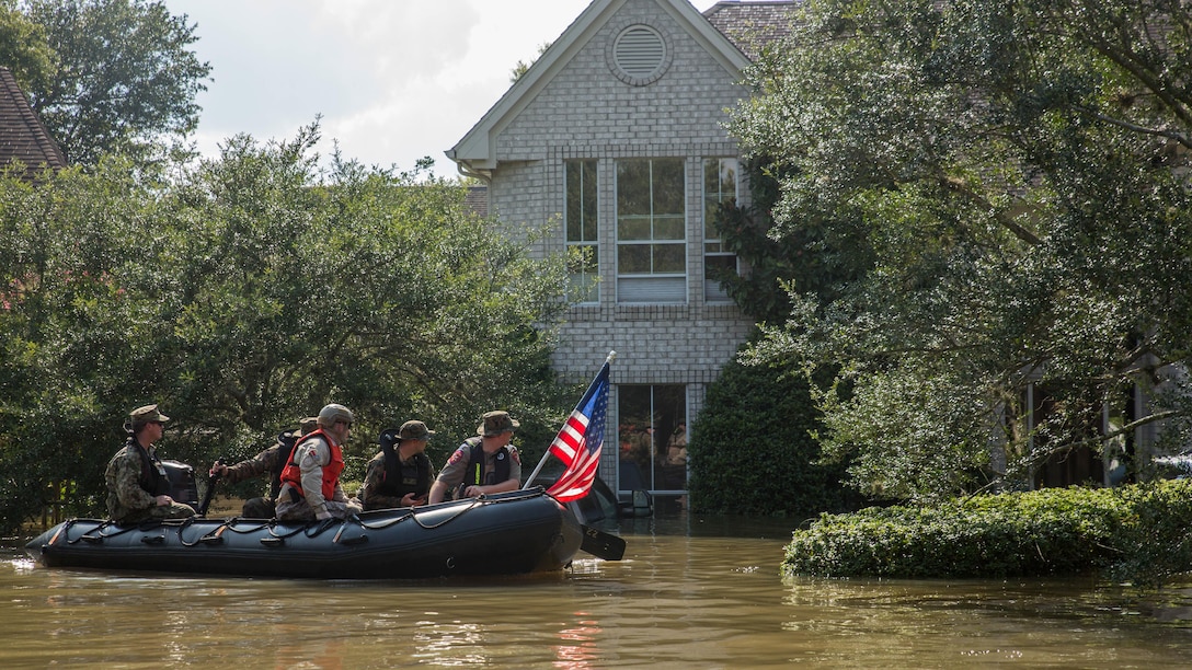 Marines with Charlie Company, 4th Reconnaissance Battalion, 4th Marine Division, Marine Forces Reserve, along with a member of the Texas Highway Patrol and Texas State Guard, patrol past a flooded house in Houston, Texas, Aug. 31, 2017. Hurricane Harvey landed Aug. 25, 2017, flooding thousands of homes and displaced over 30,000 people.