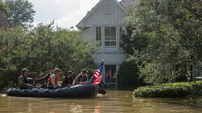 Marines with Charlie Company, 4th Reconnaissance Battalion, 4th Marine Division, Marine Forces Reserve, along with a member of the Texas Highway Patrol and Texas State Guard, patrol past a flooded house in Houston, Texas, Aug. 31, 2017. Hurricane Harvey landed Aug. 25, 2017, flooding thousands of homes and displaced over 30,000 people.