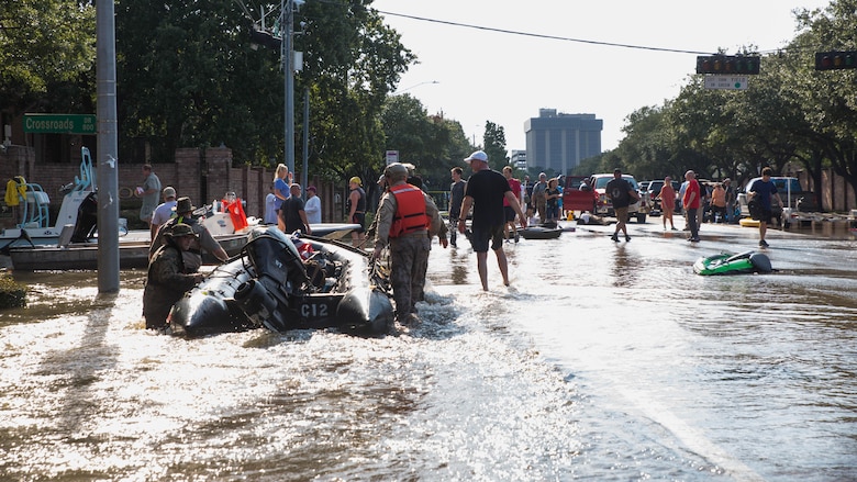 Marines with Charlie Company, 4th Reconnaissance Battalion, 4th Marine Division, Marine Forces Reserve, along with members of the Texas Highway Patrol and Texas State Guard, pull Marine Corps F470 Zodiacs Combat Rubber Raiding crafts through a flooded street in Houston, Texas, Aug. 31, 2017. Hurricane Harvey landed Aug. 25, 2017, flooding thousands of homes and displaced over 30,000 people.