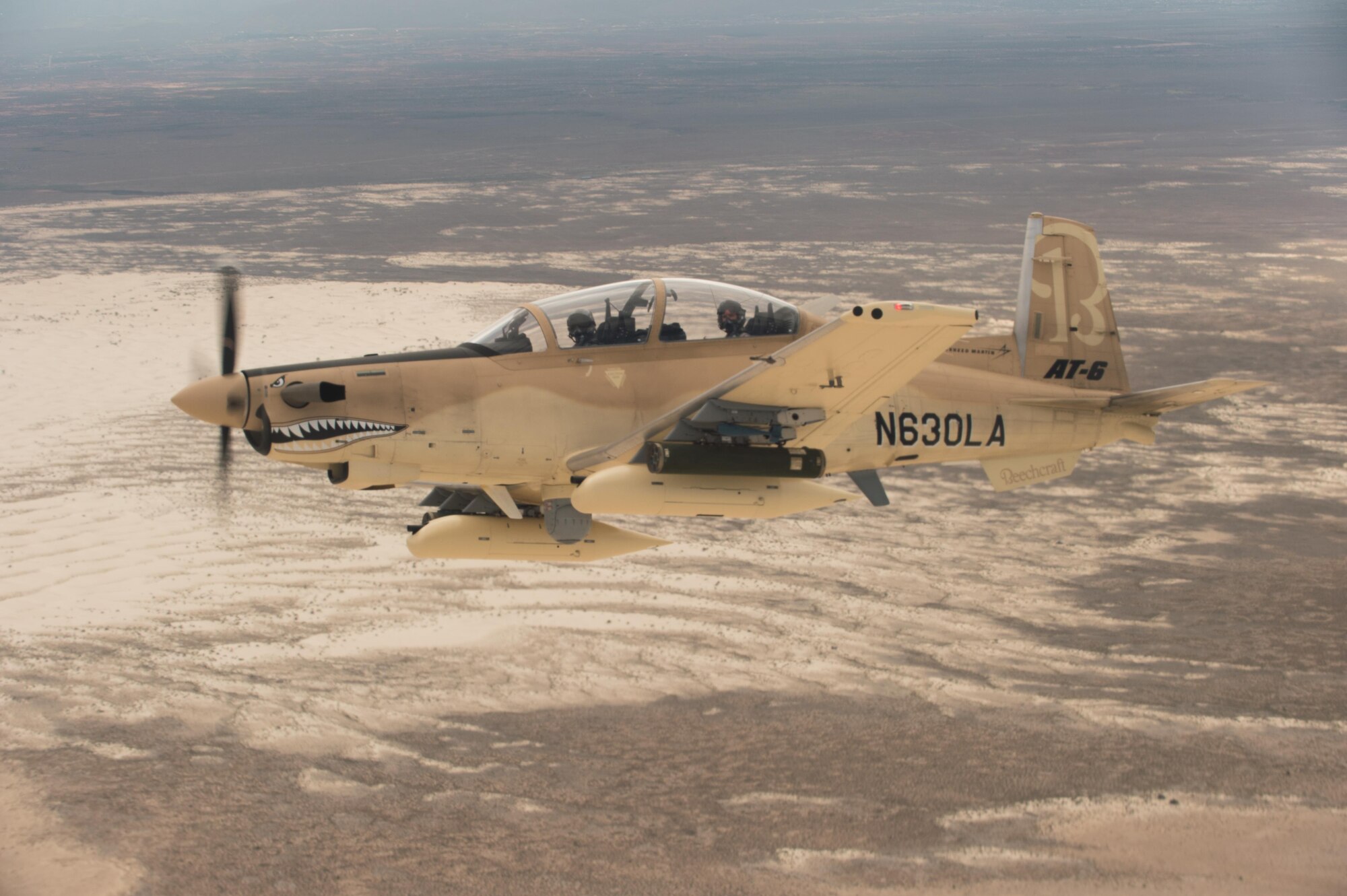 A Beechcraft AT-6 experimental aircraft flies over White Sands Missile Range, New Mexico, July 31. The AT-6 is participating in the U.S. Air Force Light Attack Experiment (OA-X), a series of trials to determine the feasibility of using light aircraft in attack roles. (U.S. Air Force photo by Ethan Wagner)