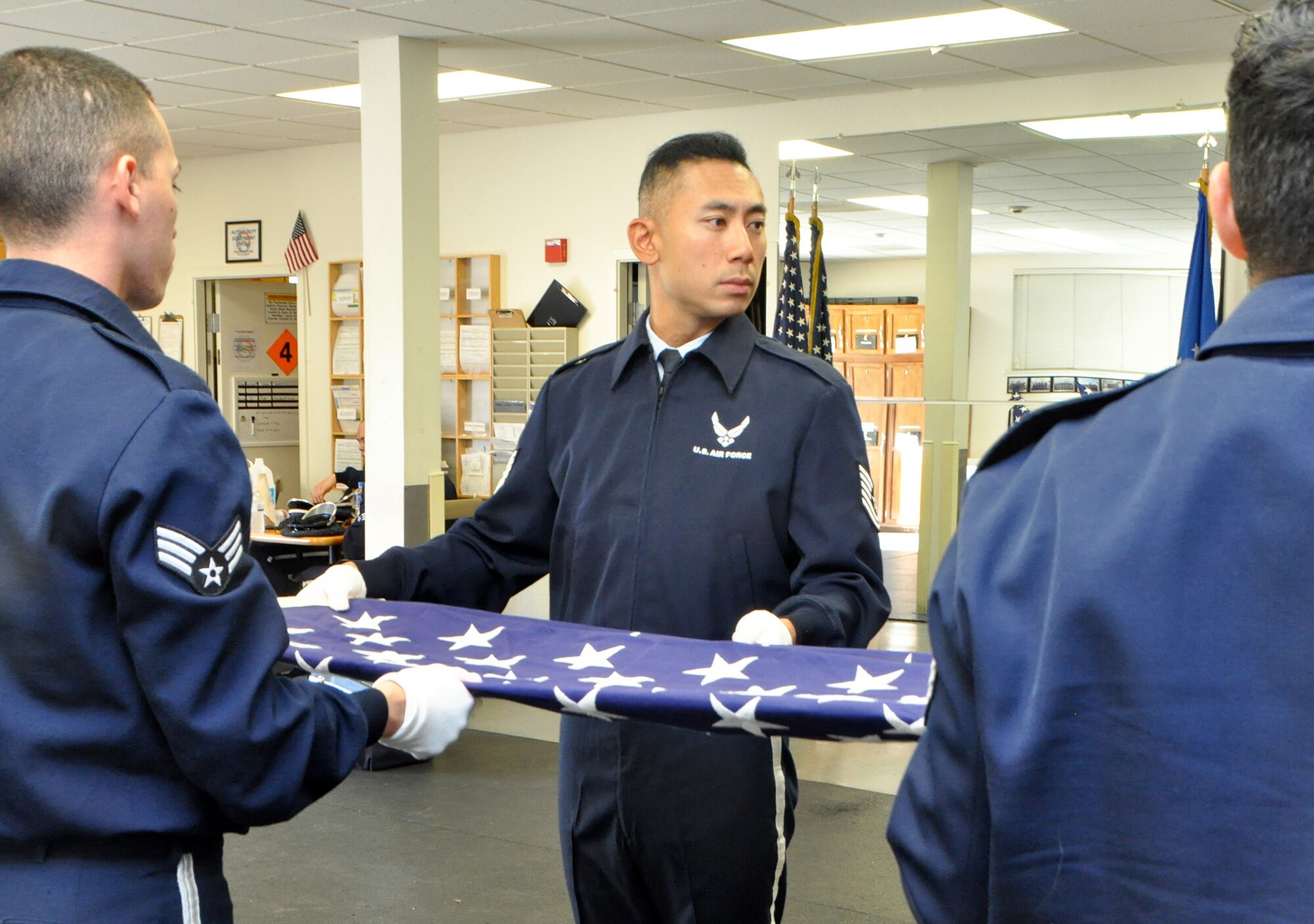 Tech. Sgt. Jason Chan, head trainer for the Travis Air Force Base Honor Guard, supervises flag folding practice, July 6, 2017.