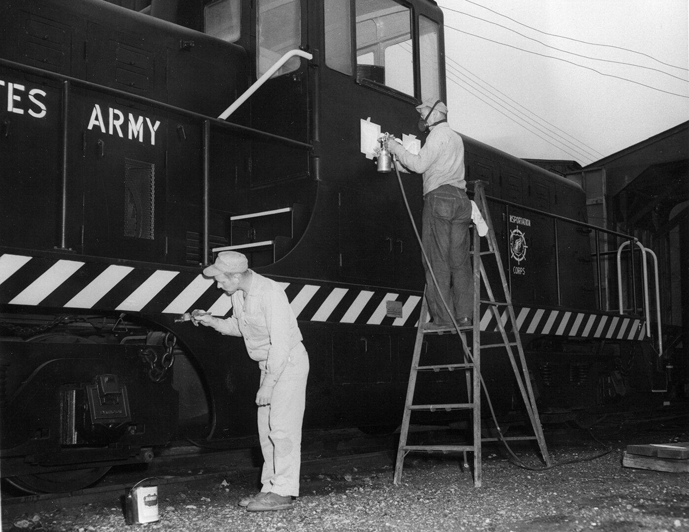 Workers refresh paint on a train engine at the New Cumberland Army Depot during the late 1960s.