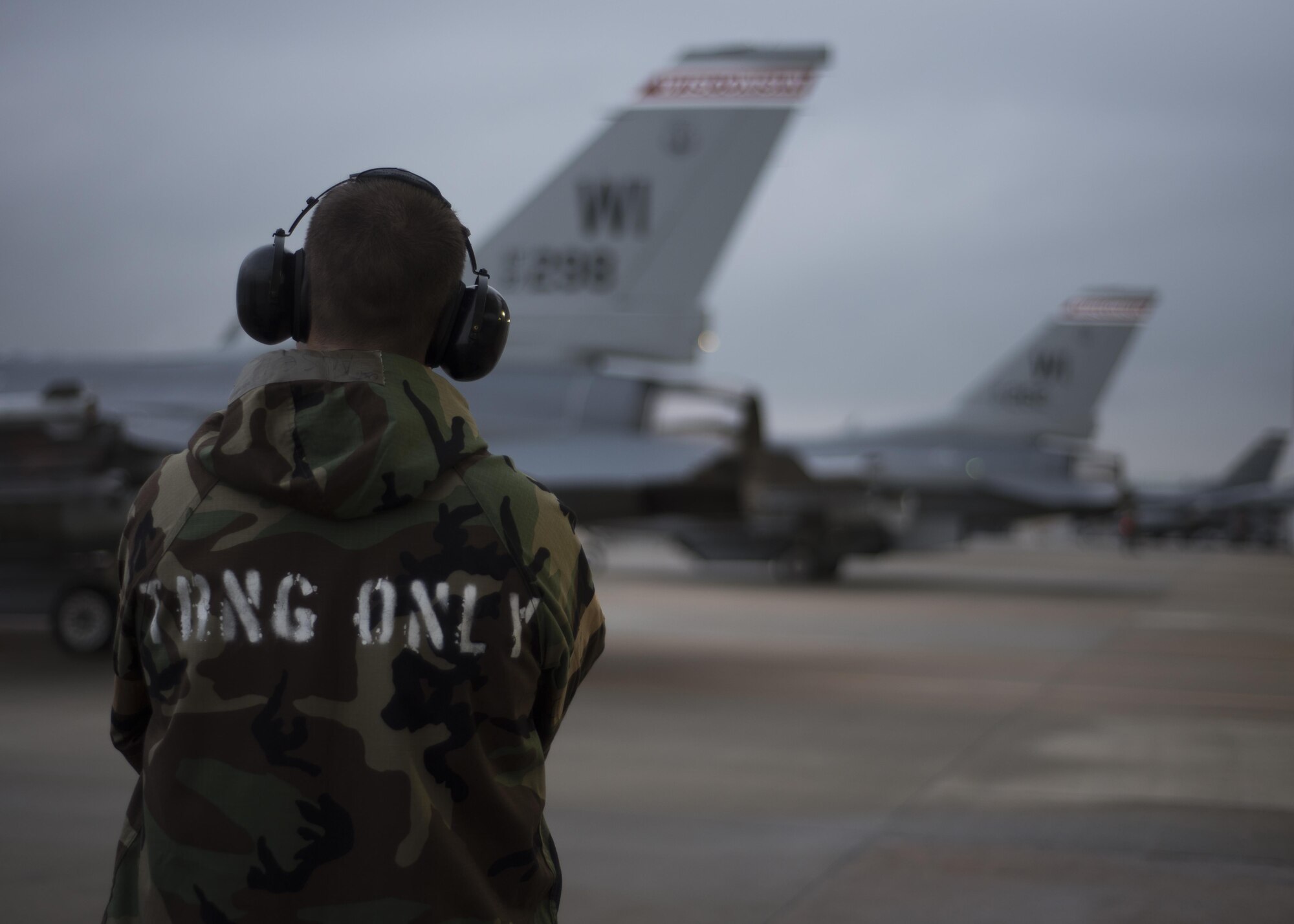 U.S. Air Force Staff Sgt. Andrew Ausel, 115th Aircraft Maintenance Squadron weapons load crew member, assigned to the Wisconsin Air National Guard, watches as four F-16 Fighting Falcons prepare to taxi down the runway at Kunsan Air Base, Republic of Korea, Aug. 22, 2017. The 115th Fighter Wing participated in a regularly-scheduled operational readiness exercise, Beverly Pack 17-3, as part of a Theater Security Package deployment to Kunsan. Pacific Air Forces TSPs signify a continued commitment to regional stability and security, while allowing units to train in the Pacific theater. (U.S. Air Force photo by Staff Sgt. Victoria H. Taylor/Released)
