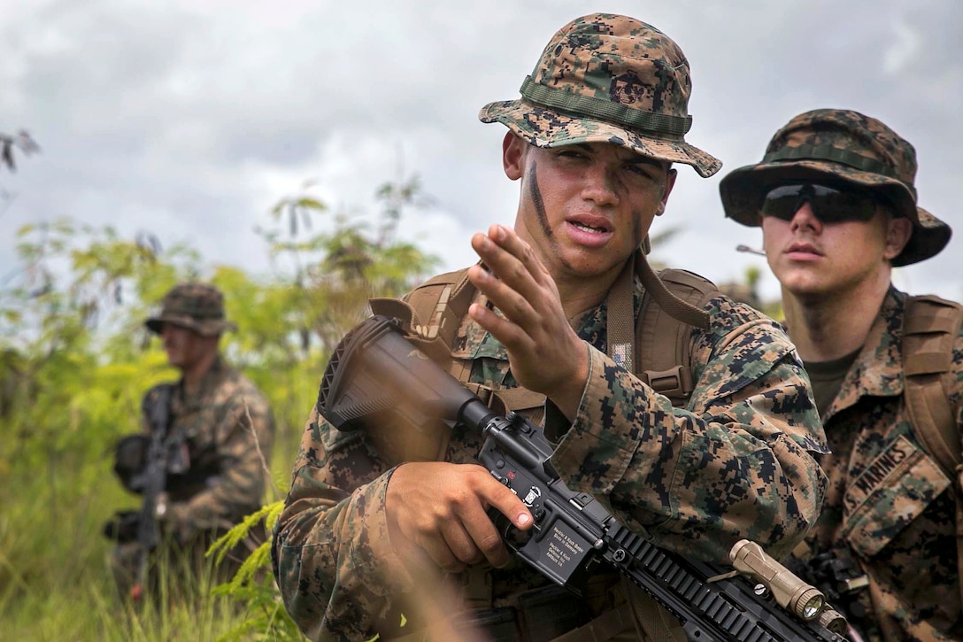 Lance Cpl. Elijah Gums, foreground, briefs another Marine on the plan to clear an abandoned building during military operations in urbanized terrain training