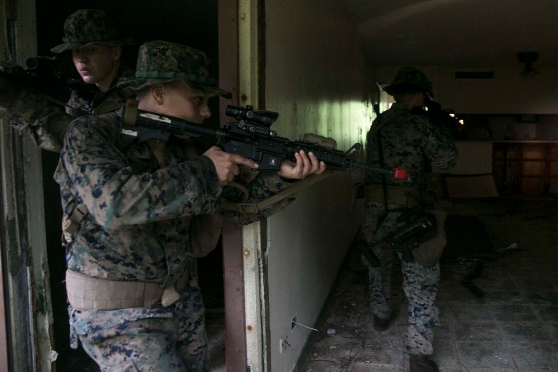 Marines with Battalion Landing Team, 3rd Battalion, 5th Marines, clear an abandoned house during Military Operations in Urbanized Terrain (MOUT) training at Andersen South Air Force Base, Guam, August 30, 2017. Marines with BLT 3/5 train regularly in different environments to maintain their readiness as the Ground Combat Element of the 31st Marine Expeditionary Unit. The 31st MEU partners with the Navy's Amphibious Squadron 11 to form the Bonhomme Richard Expeditionary Strike Group, providing a cohesive blue-green team capable of accomplishing a variety of missions across the Indo-Asia-Pacific region. (U.S. Marine Corps photo by Cpl. Amaia Unanue/Released)
