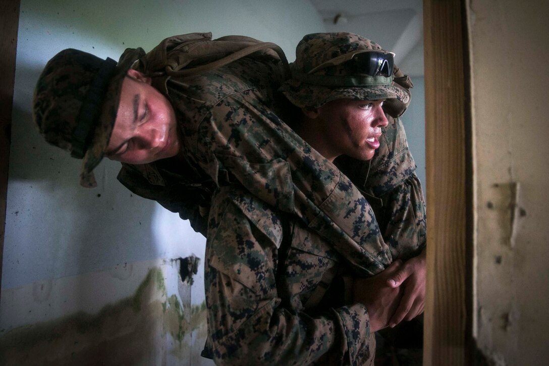 Lance Cpl. Elijah Gums, a rifleman with Battalion Landing Team, 3rd Battalion, 5th Marines, carries a notional casualty during Military Operations in Urbanized Terrain (MOUT) training at Andersen South Air Force Base, Guam, August 30, 2017. Marines with BLT 3/5 train regularly in different environments to maintain their readiness as the Ground Combat Element of the 31st Marine Expeditionary Unit. The 31st MEU partners with the Navy's Amphibious Squadron 11 to form the Bonhomme Richard Expeditionary Strike Group, providing a cohesive blue-green team capable of accomplishing a variety of missions across the Indo-Asia-Pacific region. (U.S. Marine Corps photo by Cpl. Amaia Unanue/Released)