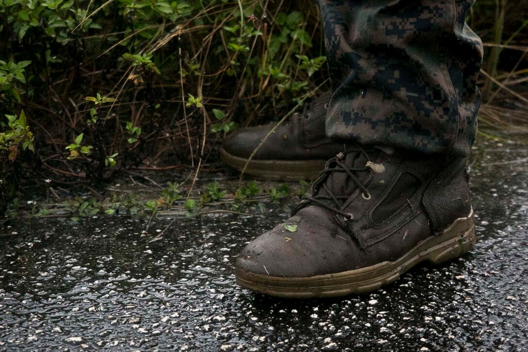 A Marine with Battalion Landing Team, 3rd Battalion, 5th Marines, takes a break before starting a patrol in the rain during Military Operations in Urbanized Terrain (MOUT) training at Andersen South Air Force Base, Guam, August 30, 2017. Marines with BLT 3/5 train regularly in different environments to maintain their readiness as the Ground Combat Element of the 31st Marine Expeditionary Unit.The 31st MEU partners with the Navy's Amphibious Squadron 11 to form the Bonhomme Richard Expeditionary Strike Group, providing a cohesive blue-green team capable of accomplishing a variety of missions across the Indo-Asia-Pacific region. (U.S. Marine Corps photo by Cpl. Amaia Unanue/Released)