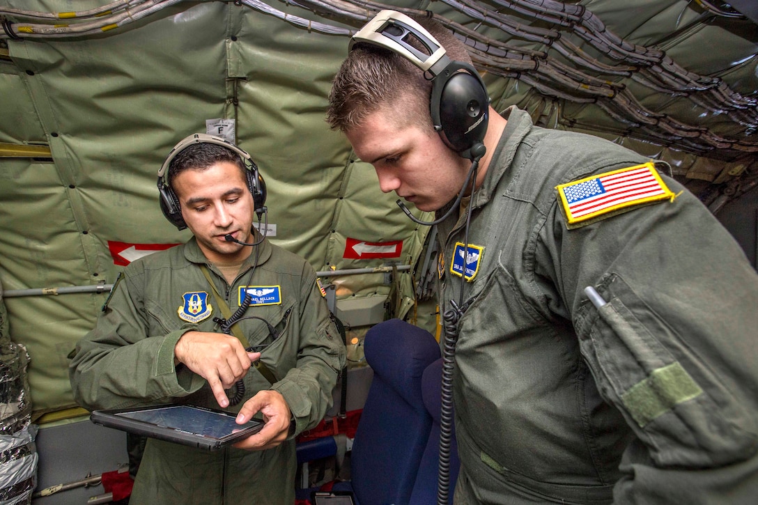 Tech. Sgt. Michael Bellack, left, reviews patient care procedures with Senior Airman Jacob N. Patterson during an aeromedical evacuation training mission