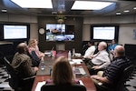 At Fort Belvoir, Virginia, senior leaders in DLA Information Operations listen as a team presents its project via video teleconference.