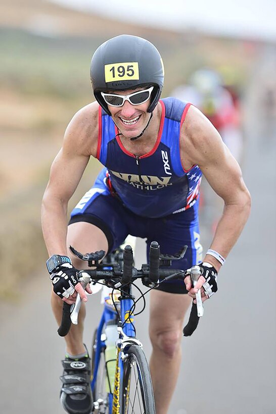Navy Lt. Cmdr. Ryan Stickel competes in the cycling portion of an Ironman triathlon.