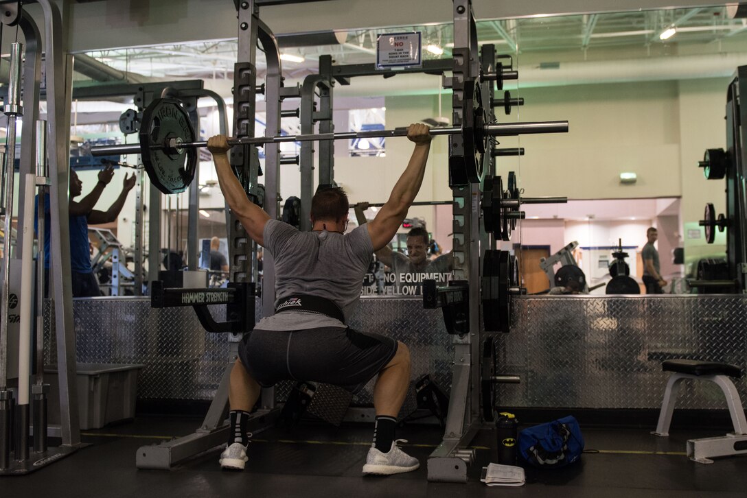 U.S. Air Force 1st Lt. James LaCoste, 633rd Force Support Squadron chief career development element, performs an overhead squat at Joint Base Langley-Eustis, Va., July 20, 2017.  LaCoste took third place overall in the physique category of the Organization of Competition Bodies' Colonial Open bodybuilding competition. (U.S. Air Force photo by Staff Sgt. J.D. Strong II)