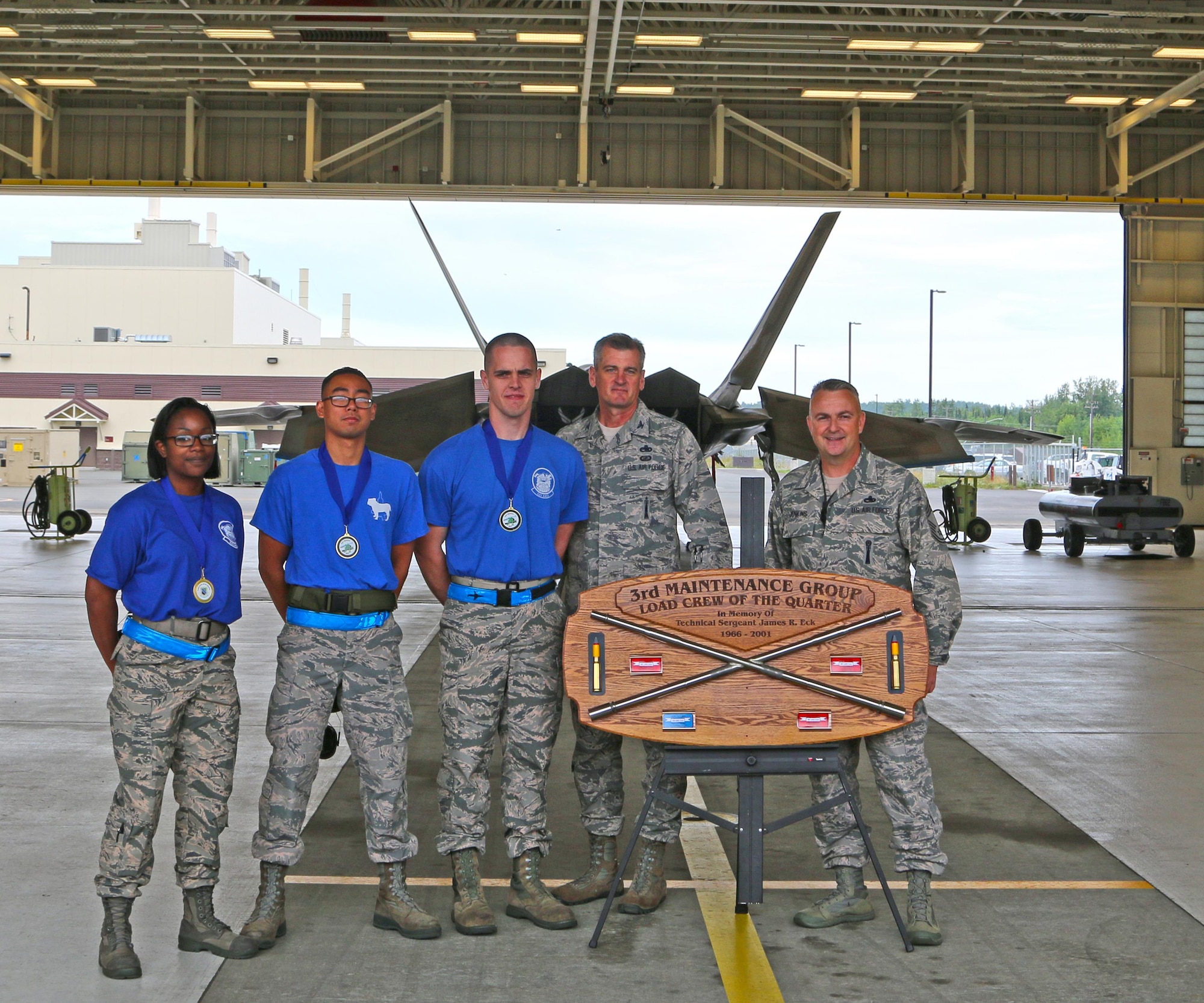 U.S. Air Force Senior Airman Kayla D. Fitzgerald, Senior Airman Chris Phantai, Staff Sgt. Jeremy R. Doerman, stands in front of the F-22 Raptor with Col. Michael L. Merritt and Chief Master Sgt. Chuck Jenkins Aug. 09, 2017,at Joint Base Elmendorf-Richardson, Alaska. The weapons load crew from the 525th Aircraft Maintenance Unit; weapons section wins the wing load crew competition in the quarterly weapons load competition at JBER, Aug. 09, 2017.