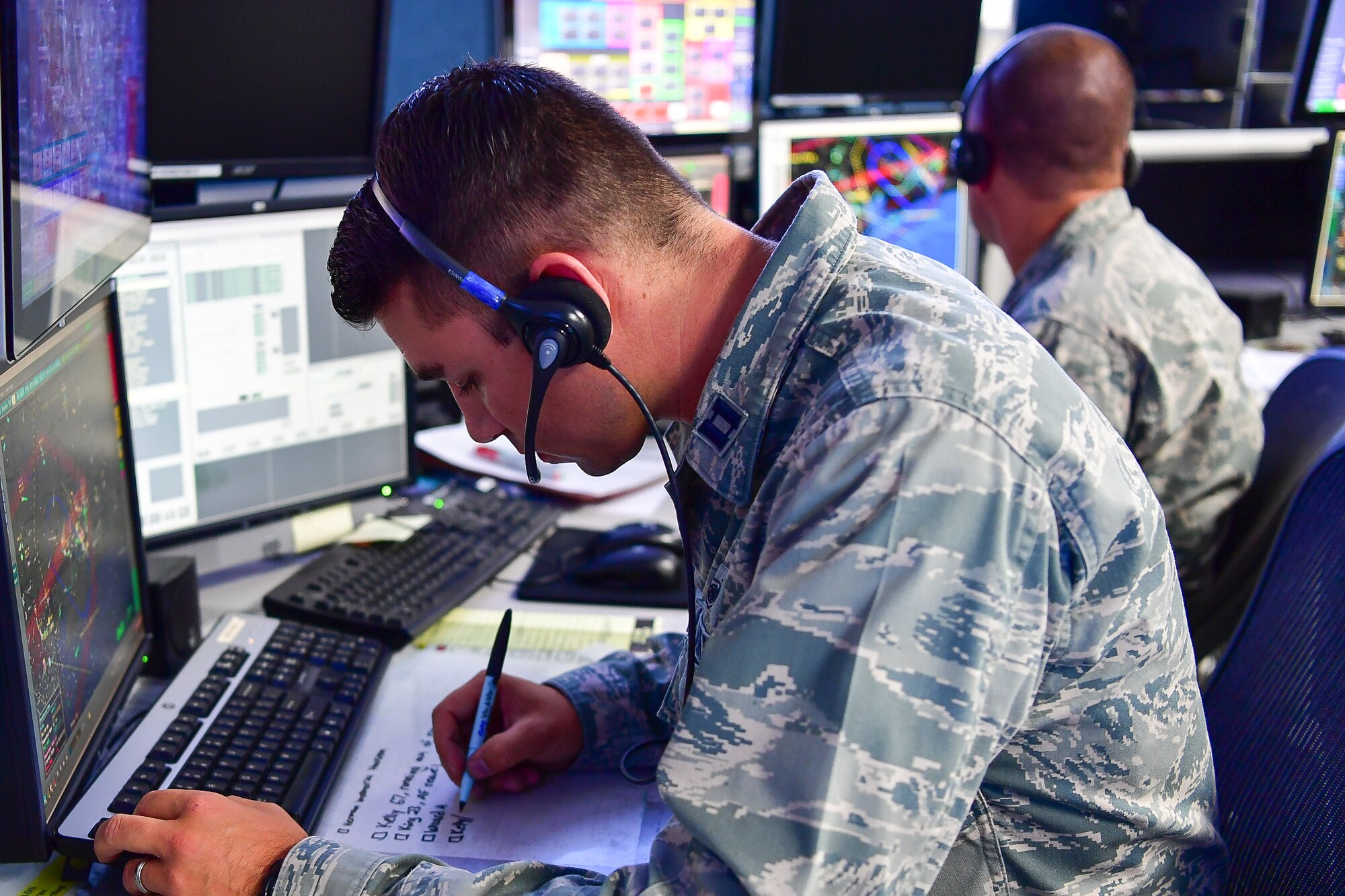 Capt. Nicholas Rhodes, WADS air battle manager, takes detailed notes while he communicates with a Hurricane Harvey victim via her cellphone.  Rhodes coordinates with an orbiting AWACS surveillance aircraft to coordinate the helicopter rescue of 11 people in Beaumont, Texas.  The caller’s two-year-old son was in dire need of medication due to a life threatening condition and her neighbor was 37 weeks pregnant and due to deliver her baby anytime.