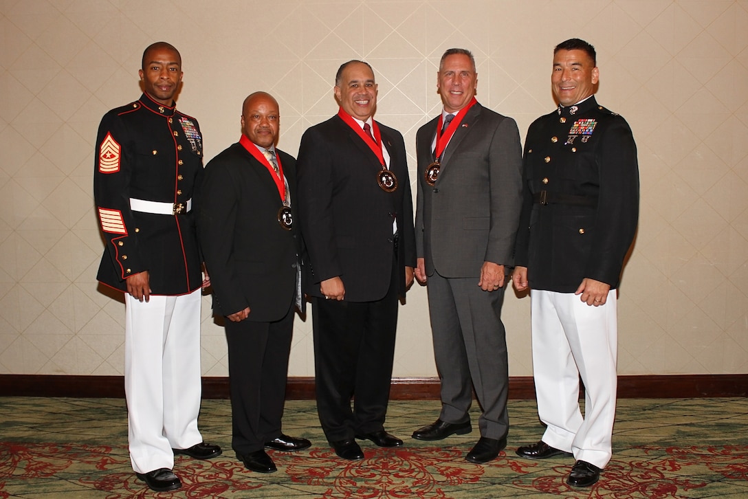 (Left to Right) Retired Master Gunnery Sergeants Kelvin Jackson, Forrester Goodrich and Philip Cashion are flanked by Sgt. Maj. Troy Nicks and Col. Keven Matthews, 8th Marine Corps District sergeant major and commanding officer, following the inaugural 8412 Hall of Fame induction ceremony August 31, 2017, in Austin, Texas. The three retirees were recognized for their immeasurable and lasting impact to both the career recruiting profession and the 8th Marine Corps District.