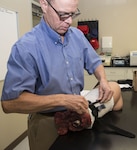 Dr. John Kragh Jr., orthopedic surgeon and researcher at the U.S. Army Institute of Surgical Research at Joint Base San Antonio-Fort Sam Houston, demonstrates how the Combat Application Tourniquet, or CAT, which is used by Soldiers on the battlefield, works on a simulated limb. Kragh is a renowned researcher and expert on the proper usage and effectiveness of tourniquets in treating wounded service members and injured civilians with limb injuries.