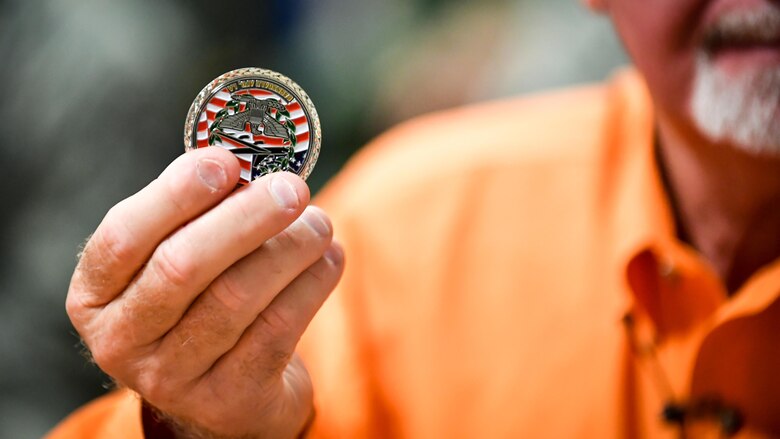 Tony Crow, It’s Not About Just Me founder, holds a coin gifted by Col. Ty Neuman, 2nd Bomb Wing commander, during a safety day briefing at Barksdale Air Force Base, La., Aug. 31, 2017. The coin was presented to Crow as a token of appreciation for sharing his story and his message on risk management and safety.
