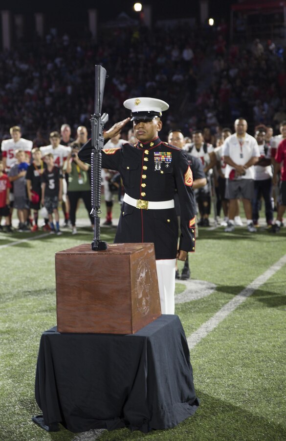 Staff Sgt. Alfredo Torres, an infantryman with 2nd Battalion, 7th Marines, places a ka-bar and rifle, in honor of the fallen Marines from 3rd Battalion, 5th Marine Regiment, during the opening ceremony of the Honor Bowl Championship Game at Cathedral Catholic High School, San Diego, Sept. 2, 2017. The Honor Bowl is an elite football tournament which highlights some of the most talented high school teams across the country, and honors service members both killed and wounded in action. (U.S. Marine Corps Photo by Sgt. Taylor Morton/Released)