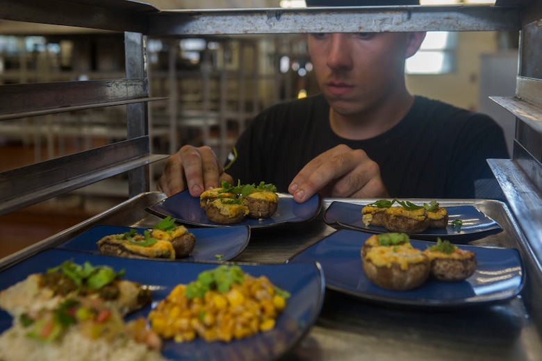 U.S. Marine Corps Lance Cpl. Bryan Carter, a food service specialist with 2nd Battalion, 3rd Marine Regiment, places his appetizer on a speed rack during the Chef of the Quarter cook-off competition at Anderson Hall aboard Marine Corps Base Hawaii, August 23, 2017. After a series of evaluations to include a 50-question written test, an oral board and a uniform inspection, the U.S. Marines with top three highest combined scores were selected to be a part of the cook-off. The competitors used chicken, curry, cream cheese and kiwi fruit as items for their appetizer, entrée and desserts. (U.S. Marine Corps photo by Cpl. Zachary Orr)