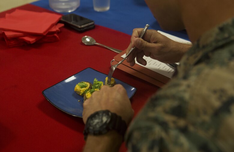 U.S. Marine Corps Gunnery Sgt. Roy Lackey, the engineer equipment chief with Marine Wing Support Detachment 24 and a judge for the cook-off, samples food during the Chef of the Quarter cook-off competition at Anderson Hall aboard Marine Corps Base Hawaii, August, 23, 2017. After a series of evaluations to include a 50-question written test, an oral board and a uniform inspection, the U.S. Marines with top three highest combined scores were selected to be a part of the cook-off. The competitors used chicken, curry, cream cheese and kiwi fruit as items for their appetizer, entrée and desserts. (U.S. Marine Corps photo by Cpl. Zachary Orr)