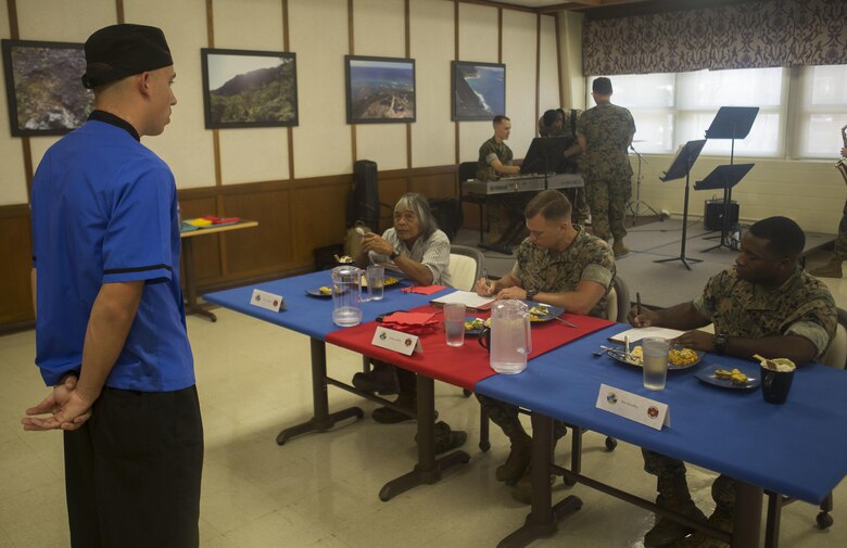 U.S. Marine Corps Lance Cpl. Brian Carter, a food service specialist with 2nd Battalion, 3rd Marine Regiment, briefs judges on his meal during the Chef of the Quarter cook-off competition at Anderson Hall aboard Marine Corps Base Hawaii, August 23, 2017. After a series of evaluations to include a 50-question written test, an oral board and a uniform inspection, the U.S. Marines with top three highest combined scores were selected to be a part of the cook-off. The competitors used chicken, curry, cream cheese and kiwi fruit as items for their appetizer, entrée and desserts. (U.S. Marine Corps photo by Cpl. Zachary Orr)