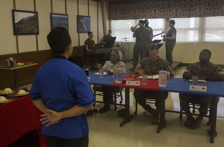 U.S. Marine Corps Lance Cpl. Cinthya CruzOrganista, a food service specialist with Headquarters Battalion, Marine Corps Base Hawaii (MCBH), briefs judges on her meal during the Chef of the Quarter cook-off competition at Anderson Hall aboard MCBH, August 23, 2017. After a series of evaluations to include a 50-question written test, an oral board and a uniform inspection, the U.S. Marines with top three highest combined scores were selected to be a part of the cook-off. The competitors used chicken, curry, cream cheese and kiwi fruit as items for their appetizer, entrée and desserts. (U.S. Marine Corps photo by Cpl. Zachary Orr)