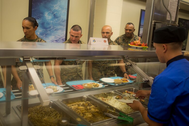 A food service specialist serves dessert during the Chef of the Quarter cook-off competition at Anderson Hall aboard Marine Corps Base Hawaii, August 23, 2017. After a series of evaluations to include a 50-question written test, an oral board and a uniform inspection, the U.S. Marines with top three highest combined scores were selected to be a part of the cook-off. The competitors used chicken, curry, cream cheese and kiwi fruit as items for their appetizer, entrée and desserts. (U.S. Marine Corps photo by Cpl. Zachary Orr)