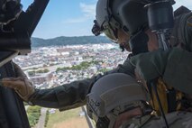 Tech. Sgt. Nicholas Poe, 459th Airlift Squadron special missions aviator, performs a visual confirmation over Odawara City