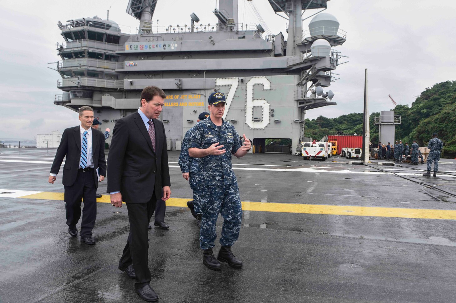 Capt. Buzz Donnelly, commanding officer of the Navy's forward-deployed aircraft carrier, USS Ronald Reagan (CVN 76), explains flight deck operations to William F. Hagerty, U.S. ambassador to Japan, on the ship's flight deck. Hagerty met with senior leadership and toured the ship during his first visit to Ronald Reagan since taking the office of U.S. ambassador to Japan in July. Ronald Reagan, the Navy’s forward-deployed aircraft carrier, provides a combat-ready force that protects and defends the collective maritime interests of the U.S. and its allies and partners in the Indo-Asia-Pacific region.