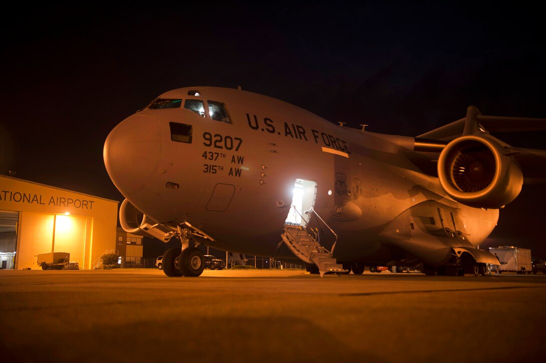 An Air Force C-17 Globemaster III sits on the runway at night.