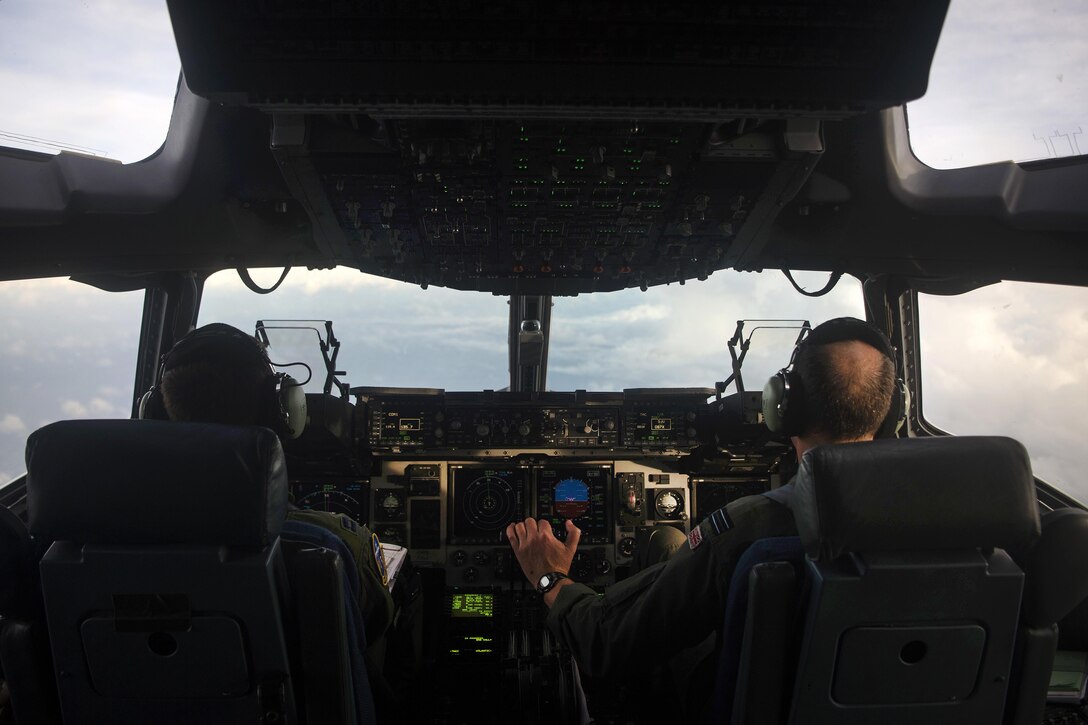 A pilot's view of an Air Force C-17 Globemaster III cockpit while the aircraft is in the air.