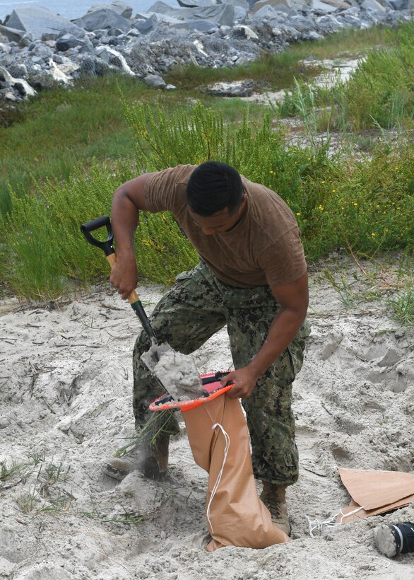 A sailor fills a sandbag in Florida.