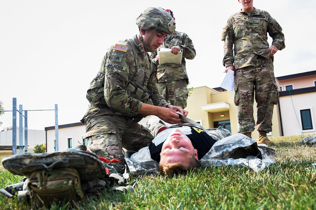 A soldier provides medical aid to a mock casualty during the best medic competition