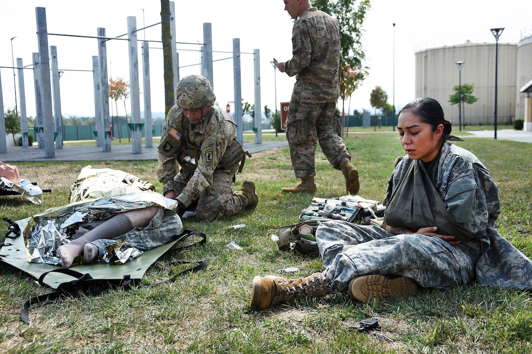 Soldiers provide medical aid to mock patients at a casualty