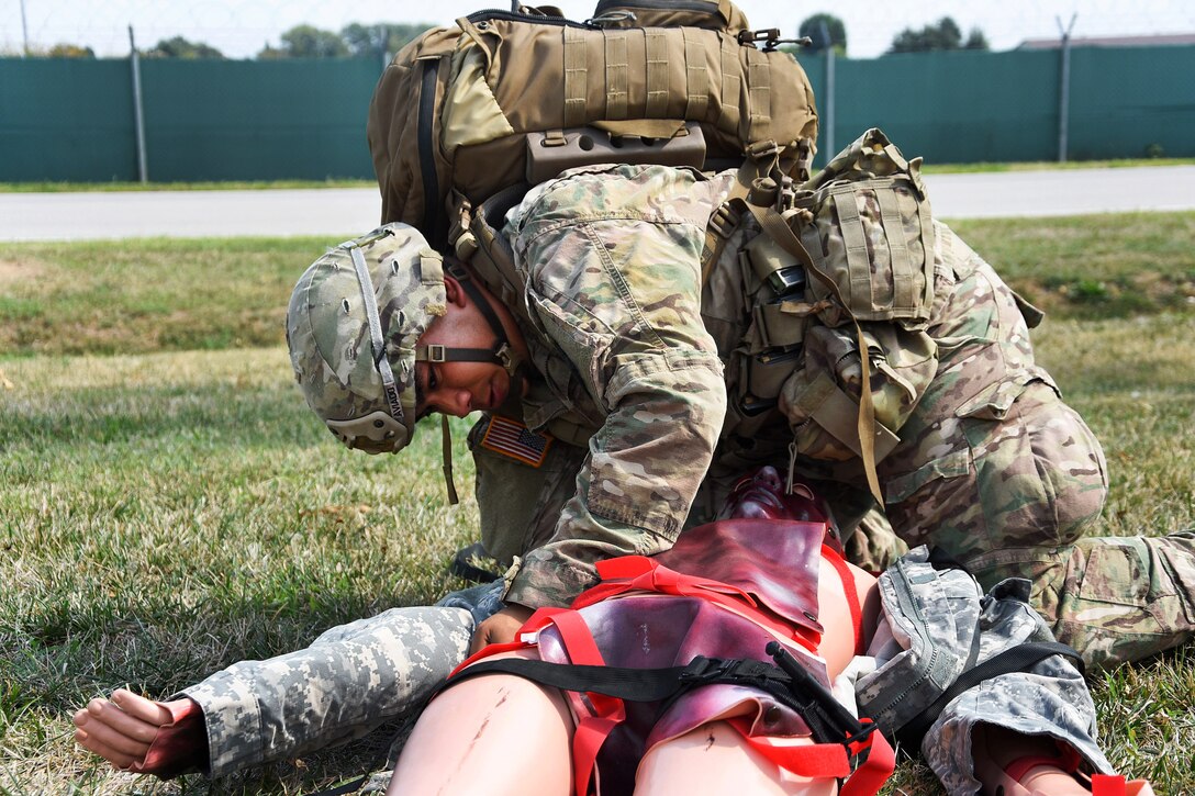 A soldier provides medical aid to a mock casualty
