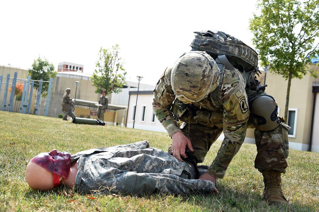 A soldier provides medical aid to mock casualty