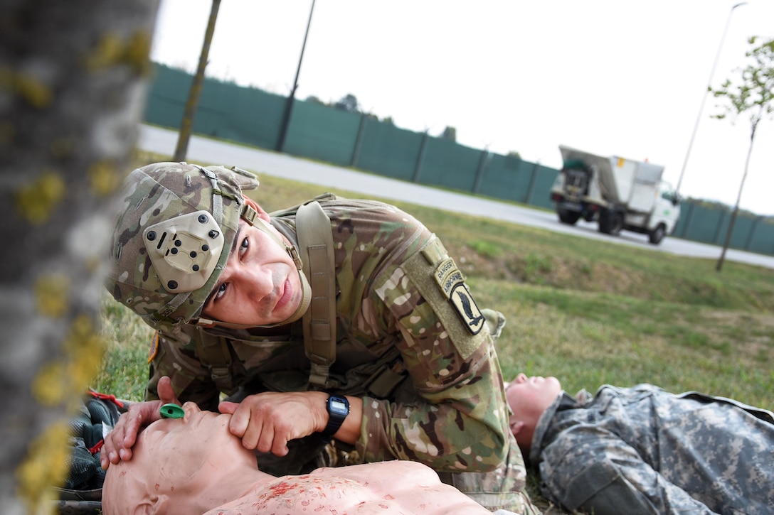 A soldier provides medical aid to a mock casualty during the Beat Medic Competition