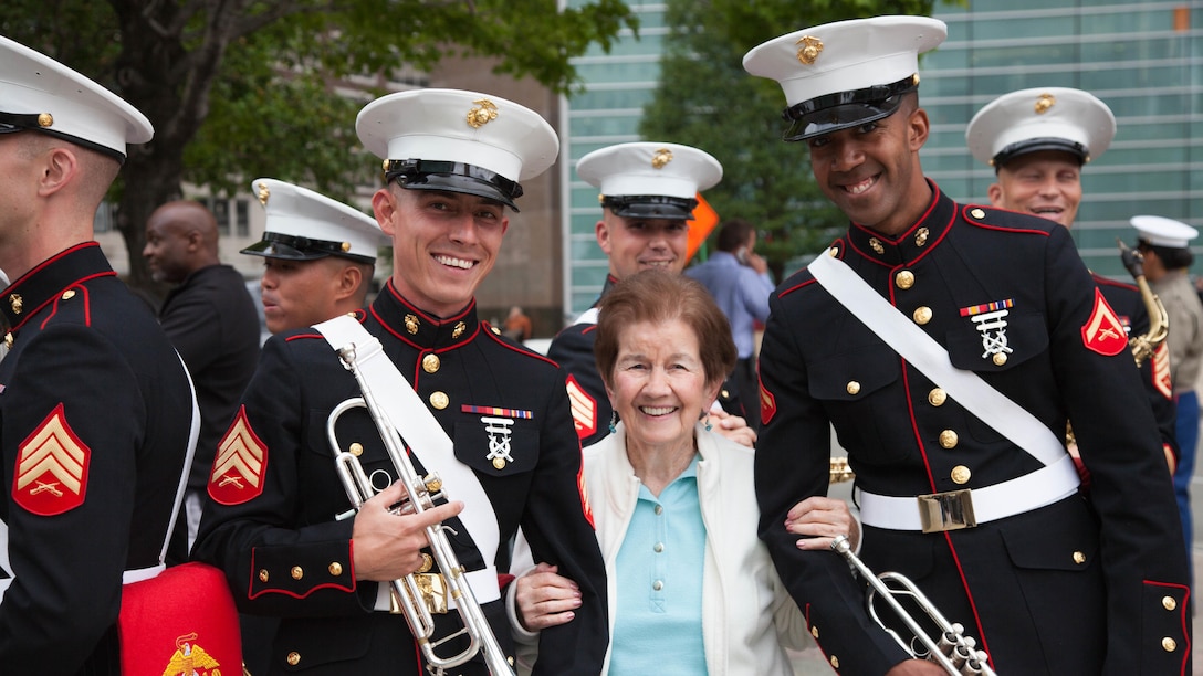 Sgt. William Hershey and Lance Cpl. Donovan Thomas from the Marine Band San Diego pose with Hershey's grandmother before their performance at Campus Martius Park, during the Marine Week Detroit opening ceremony, Sept. 6, 2017. Marine Week Detroit is an opportunity to connect with the people of the greater Detroit area, and thank them for their support.