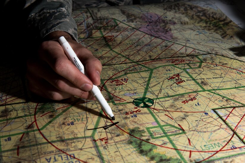 U.S. Air Force Senior Airmen John Hartin, 94th Fighter Squadron all source intelligence analyst, details exercise targeted locations during Red Flag 17-4 at Nellis Air Force Base, Nev., Aug. 23, 2017. The map provided the mission commander the intelligence needed to help prepare a plan of attack during a combat scenario. (U.S. Air Force photo by Staff Sgt. Carlin Leslie)